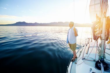 Man on sailing boat at sunrise