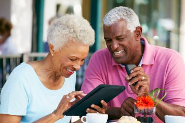 African american couple smiling looking at tablet