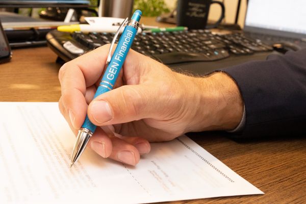 Hand with GEN financial pen writing